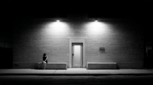 Woman sitting alone by a rainy window while trying to accept a breakup